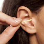 Lady using a QTip to clean ears