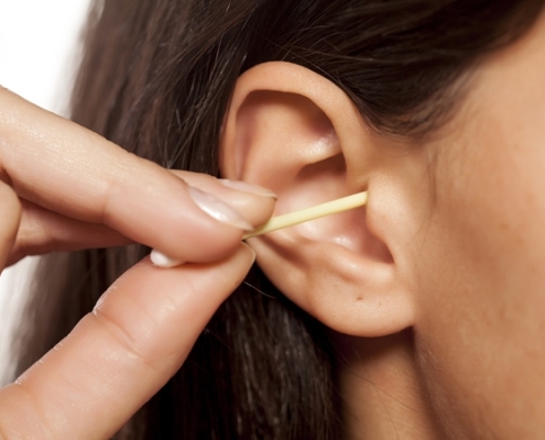 Lady using a QTip to clean ears