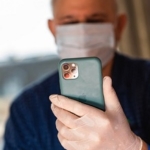 man wearing mask using cell phone