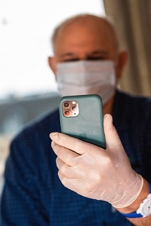 man wearing mask using cell phone