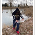 Teen holding pond ice sheet