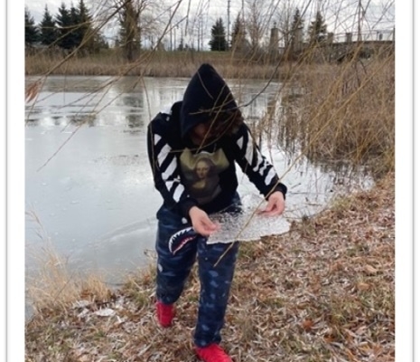 Teen holding pond ice sheet