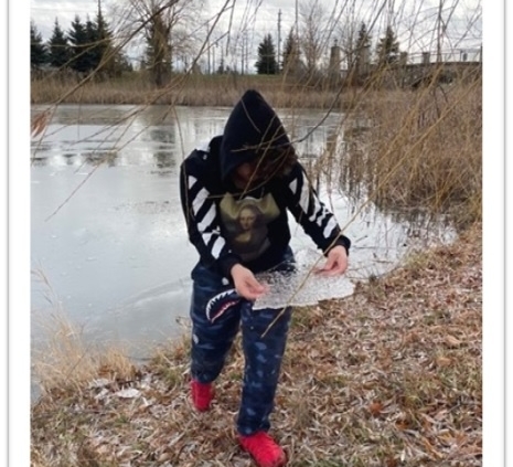 Teen holding pond ice sheet