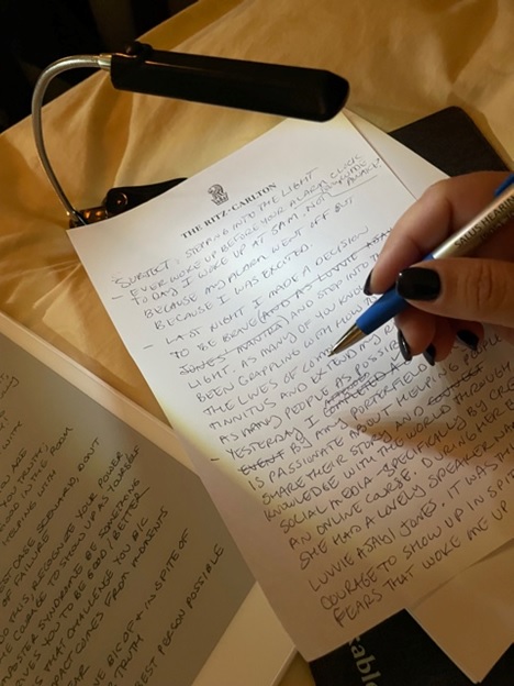 Sabrina DeToma writing a rough draft of a blog post on paper 